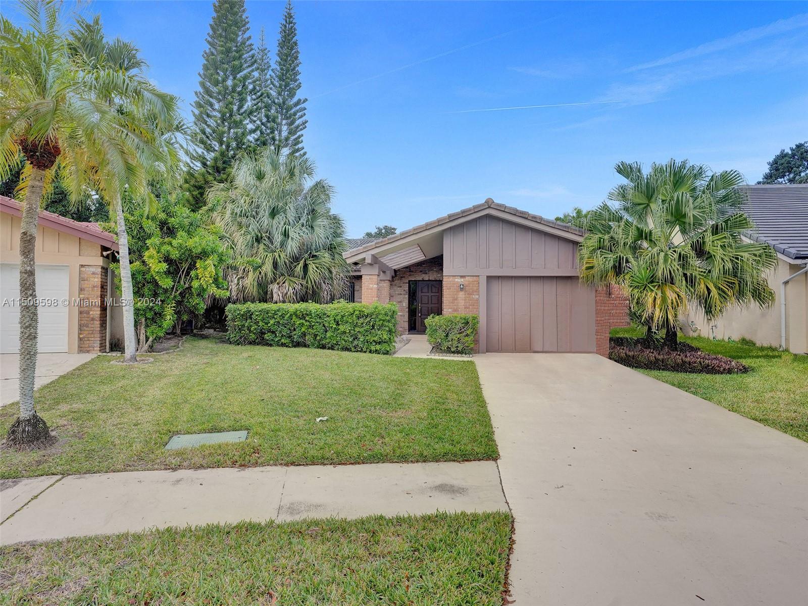 19621 Back 9 Drive Boca Raton, FL 33498 - Photo 44 of 45 a front view of a house with a yard and garage