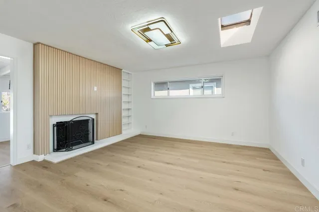 a view of an empty room with a fireplace and a window