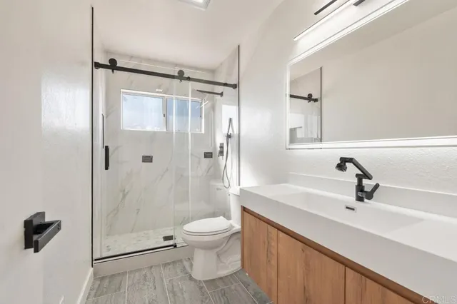 a bathroom with a sink a toilet and shower