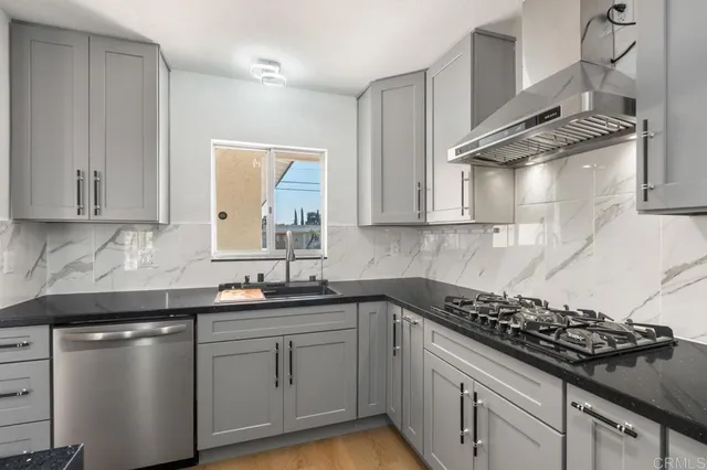 a kitchen with stainless steel appliances a sink a stove and cabinets