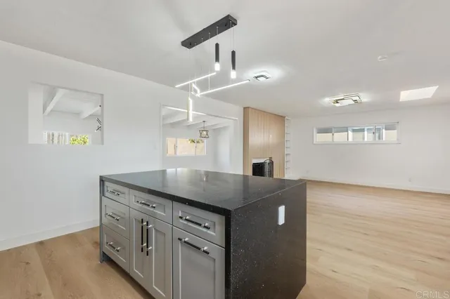 a kitchen with stainless steel appliances granite countertop a sink a stove and a wooden floors