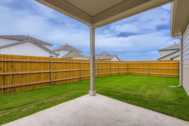a view of a backyard with wooden fence