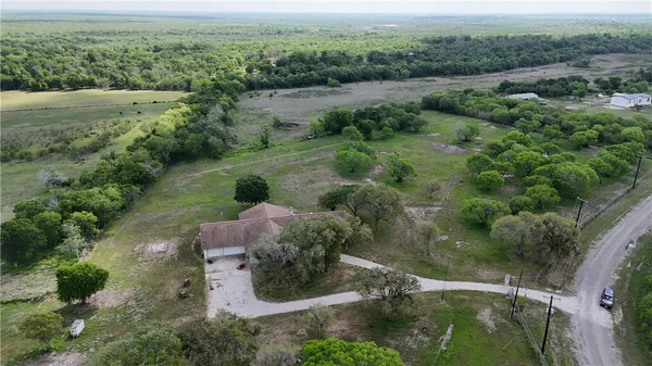 an aerial view of green landscape with trees houses and mountain view
