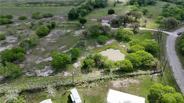 an aerial view of a house with a yard and lake