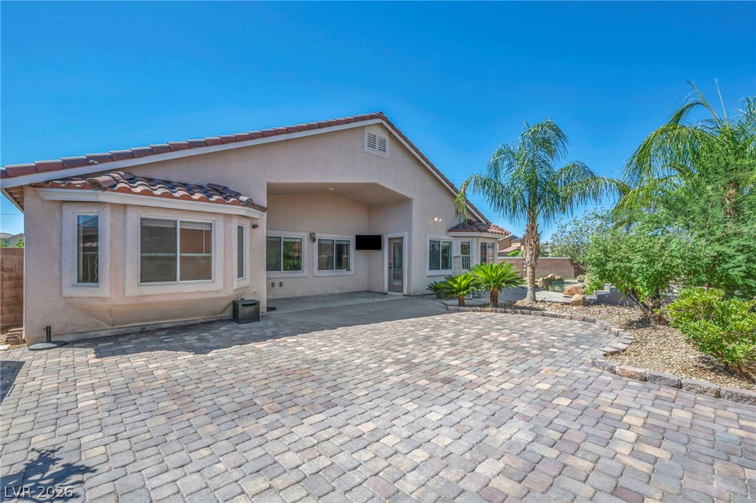 6405 North Raptor Court North Las Vegas, NV 89084 - Photo 42 of 66 A vast paver driveway welcomes you to this desert home, featuring lush palm trees and verdant landscaping.