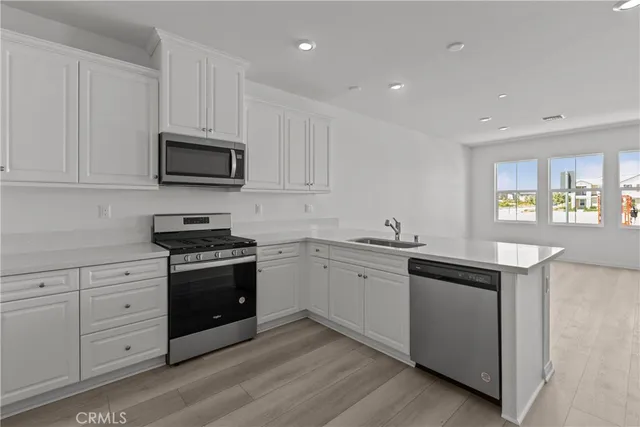 a kitchen with granite countertop white cabinets and stainless steel appliances