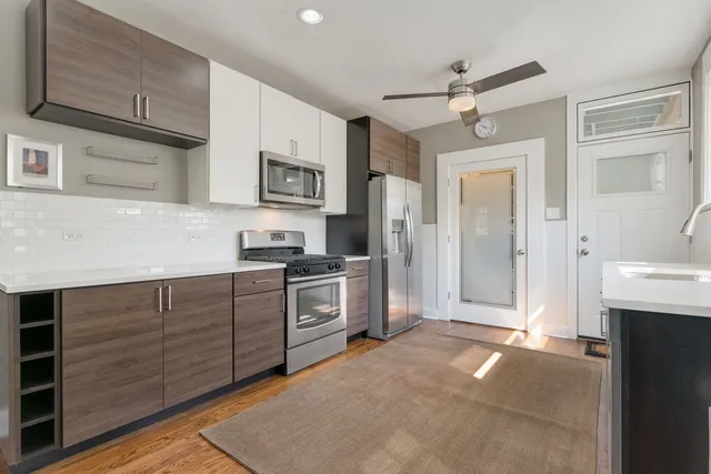 a kitchen with stainless steel appliances granite countertop a refrigerator and a stove top oven