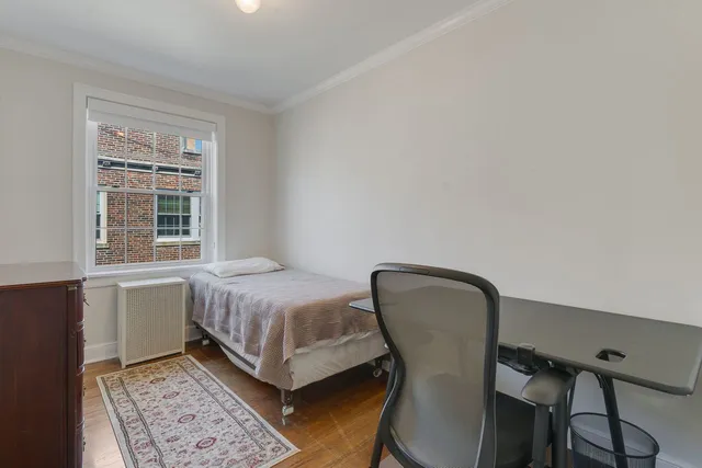 a bedroom with a bed chair and window