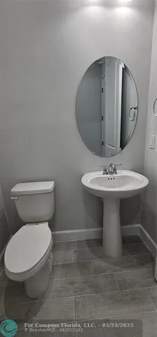a white toilet sitting next to a bathroom sink