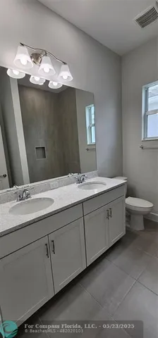 a bathroom with a double vanity sink and mirror