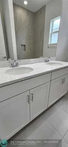 a bathroom with a double vanity sink and a mirror
