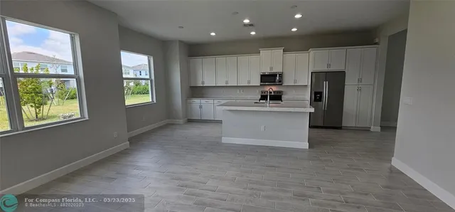 a kitchen with a refrigerator and a stove top oven