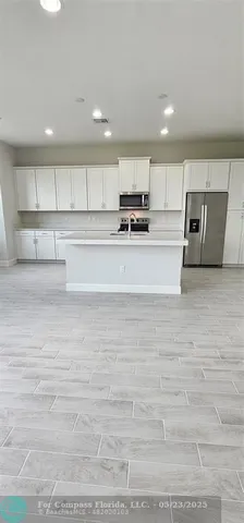 a view of kitchen with stainless steel appliances cabinets