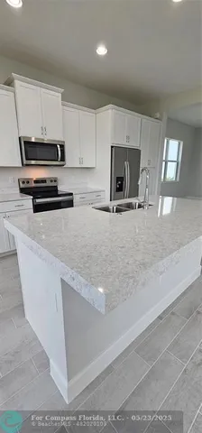 a kitchen with granite countertop a stove and a microwave