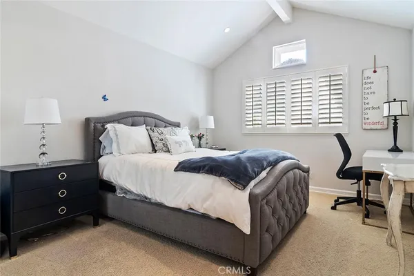 a bedroom with a bed a lamp and a window