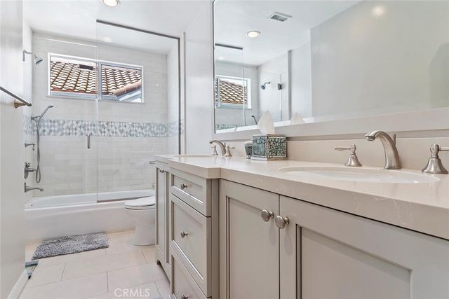 a bathroom with a toilet a sink a mirror a bathtub and shower