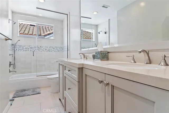 a bathroom with a toilet a sink a mirror a bathtub and shower