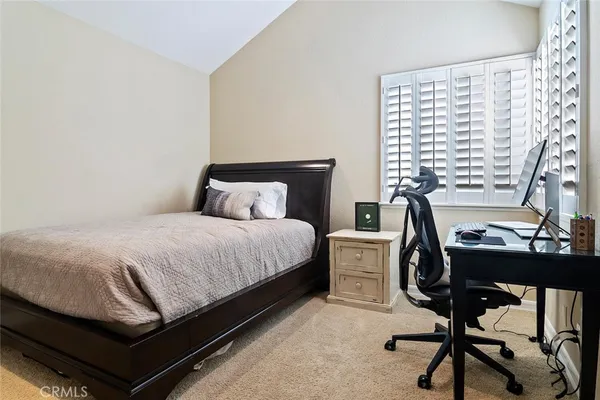 a bedroom with a bed window and a desk