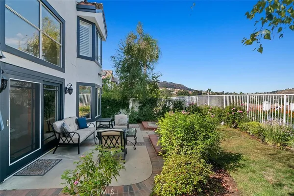 a view of a patio with couches table and chairs and potted plants