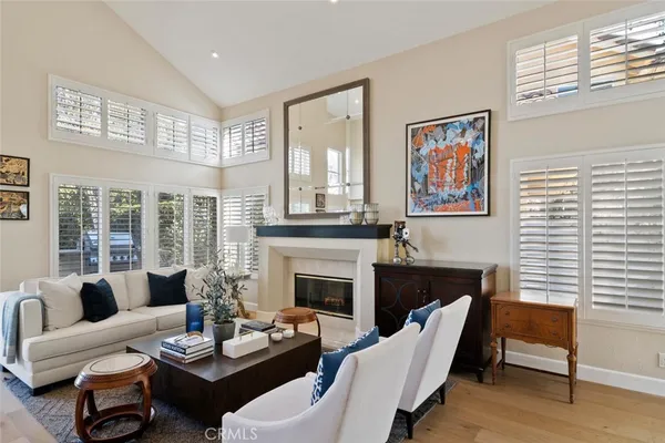 a living room with furniture two windows and a fireplace