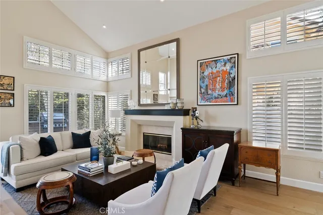 a living room with furniture two windows and a fireplace