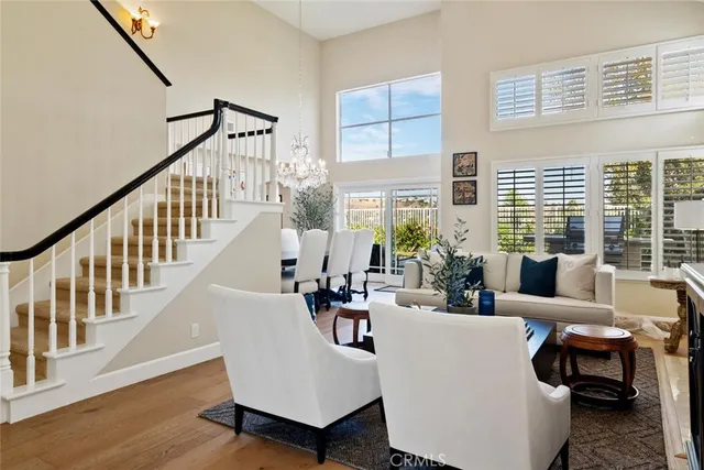 a living room with furniture stairs and a large window