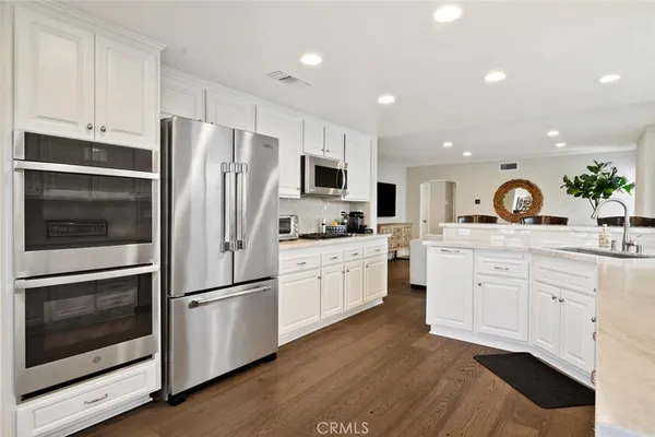 a kitchen with white cabinets and stainless steel appliances