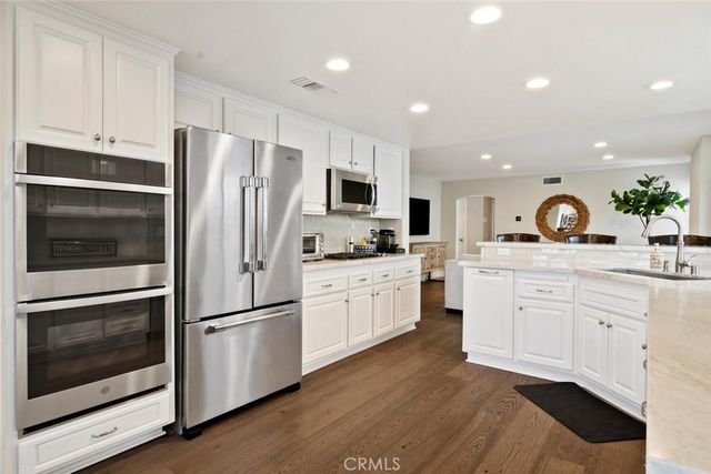a kitchen with white cabinets and stainless steel appliances