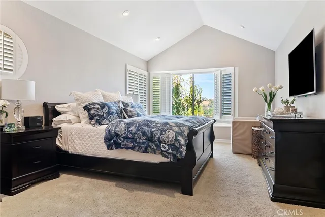 a bedroom with a bed and a flat screen tv