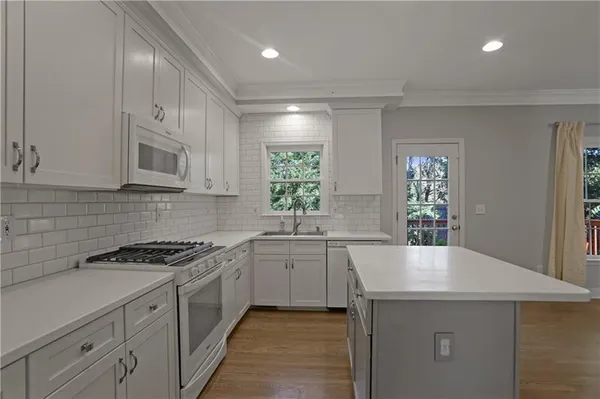 a kitchen with granite countertop a sink stove and cabinets