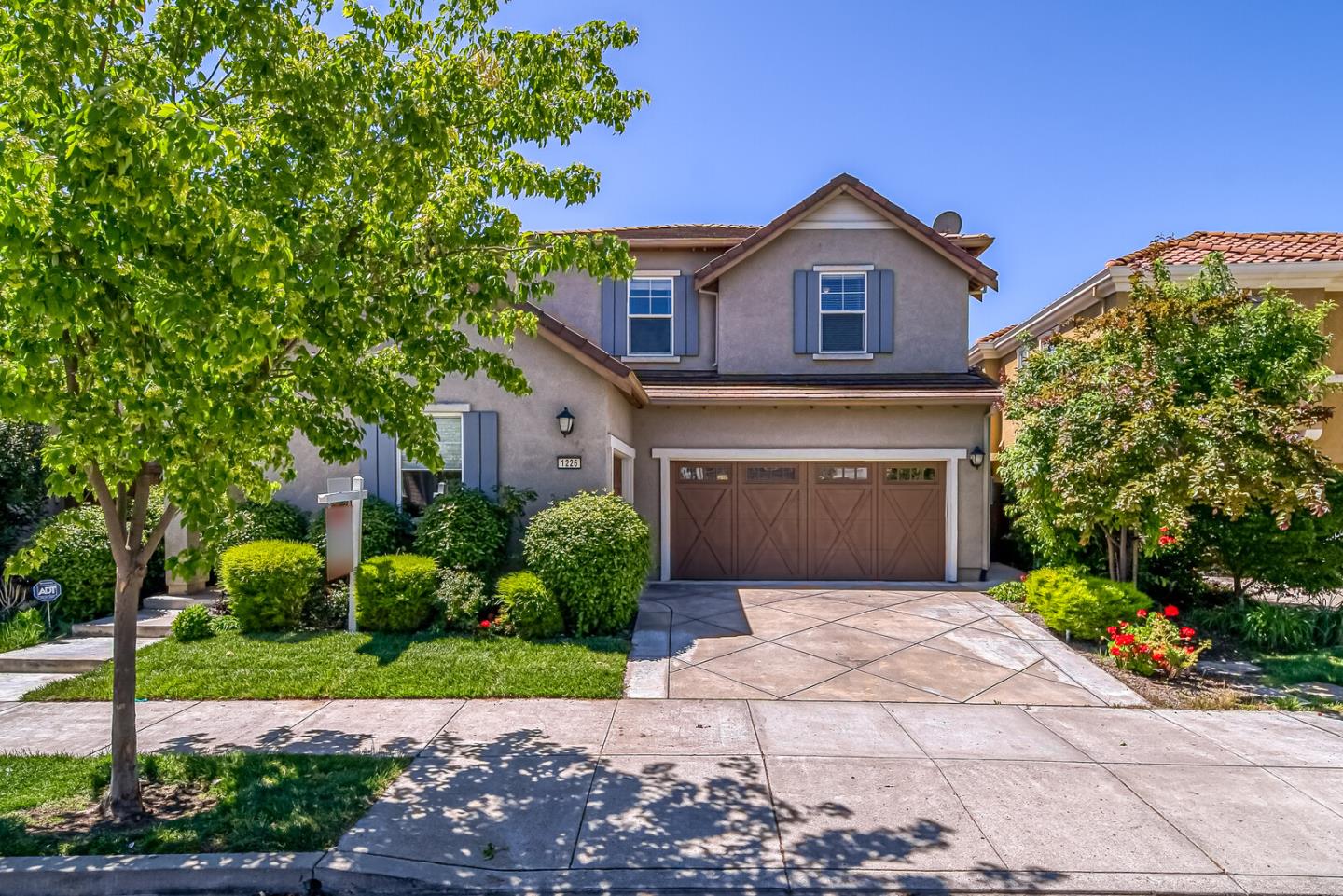 a front view of a house with a garden and plants