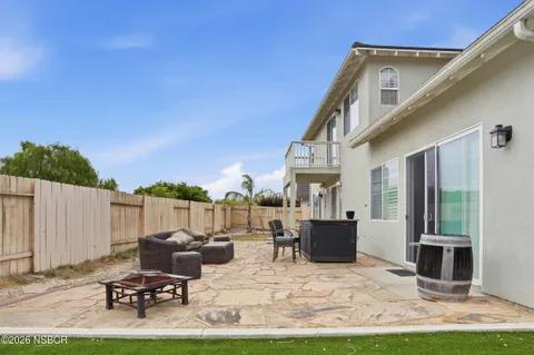 a view of a patio with table and chairs a barbeque grill with wooden fence