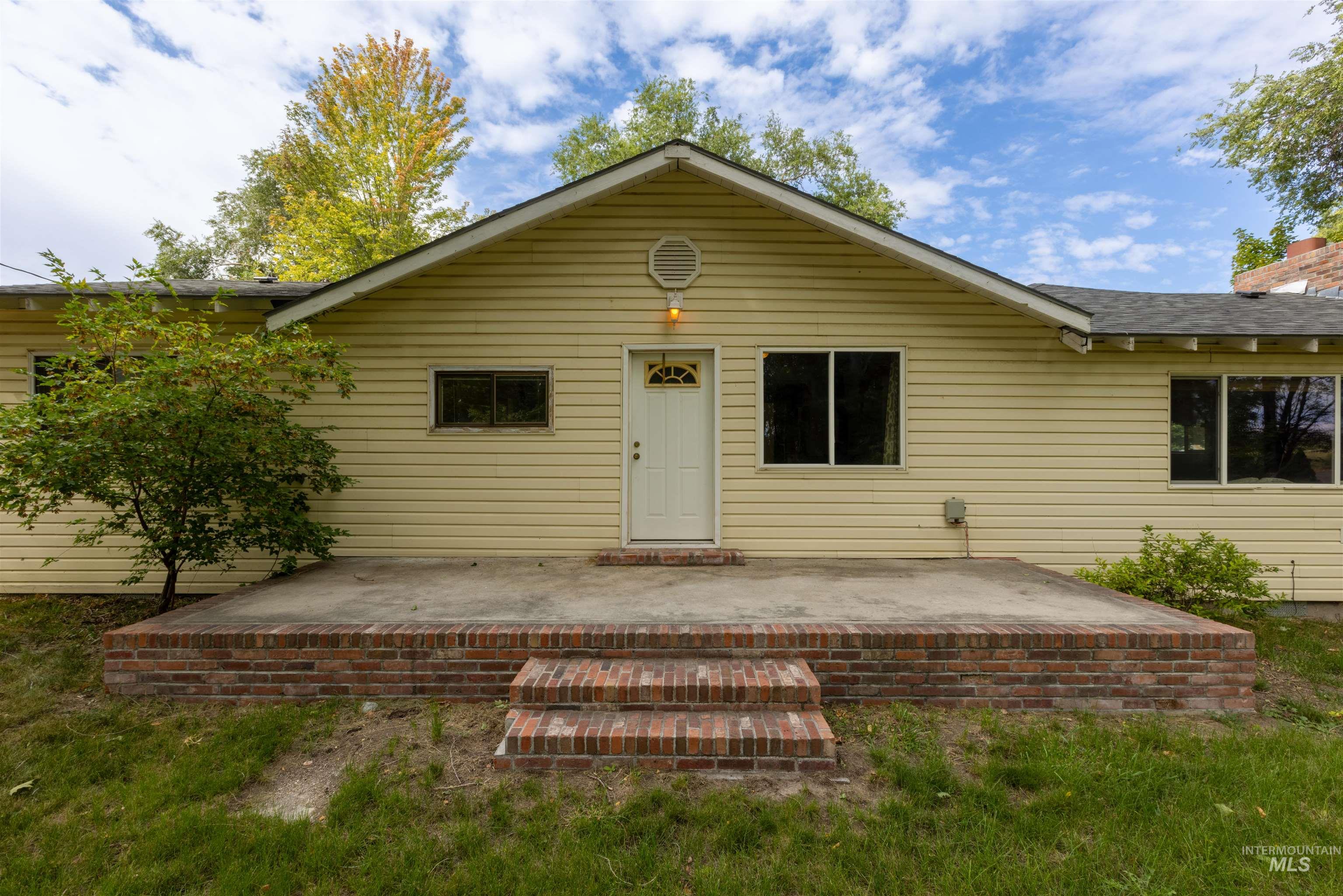 Front of house featuring a patio, roof with shingles, and a yard