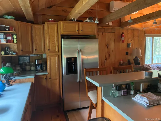 a kitchen with stainless steel appliances granite countertop a refrigerator a stove and a sink with wooden cabinets