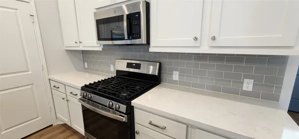 a kitchen with a sink stainless steel appliances a refrigerator and cabinets
