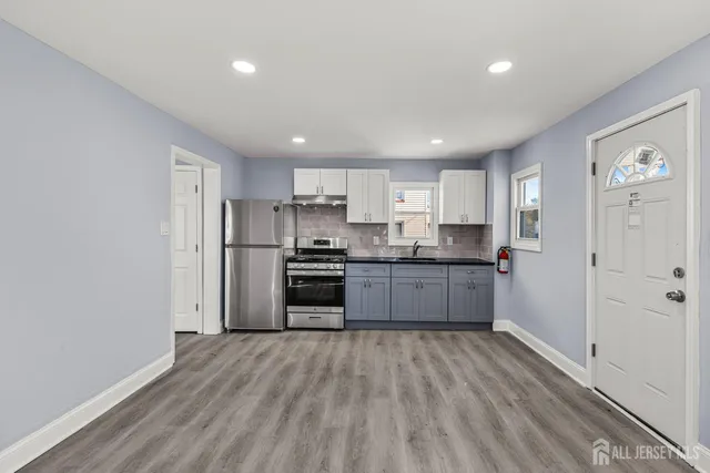 a kitchen with a refrigerator and a stove top oven