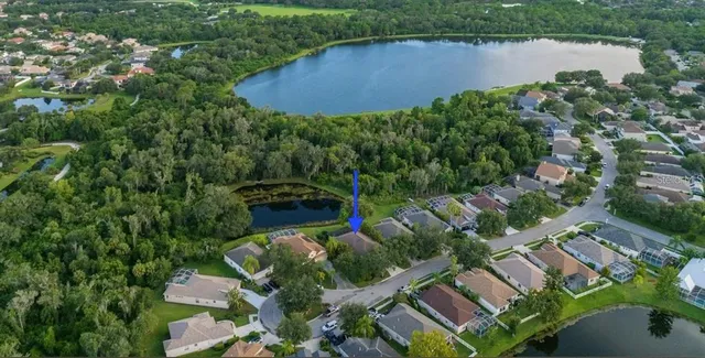 an aerial view of a house with a yard and lake view