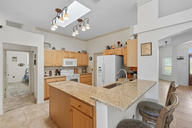 a kitchen with sink refrigerator and dining table