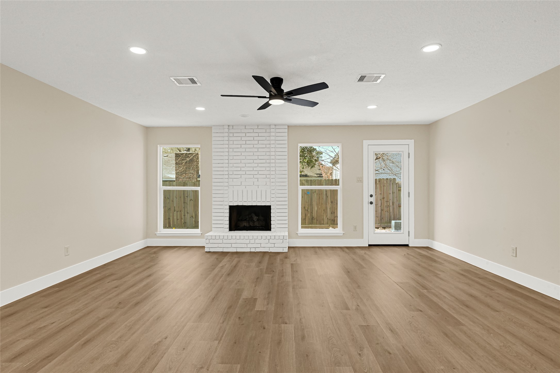 3203 Falling Brook Drive Houston, TX 77345 - Photo 13 of 27 a view of an empty room with a fireplace and a window