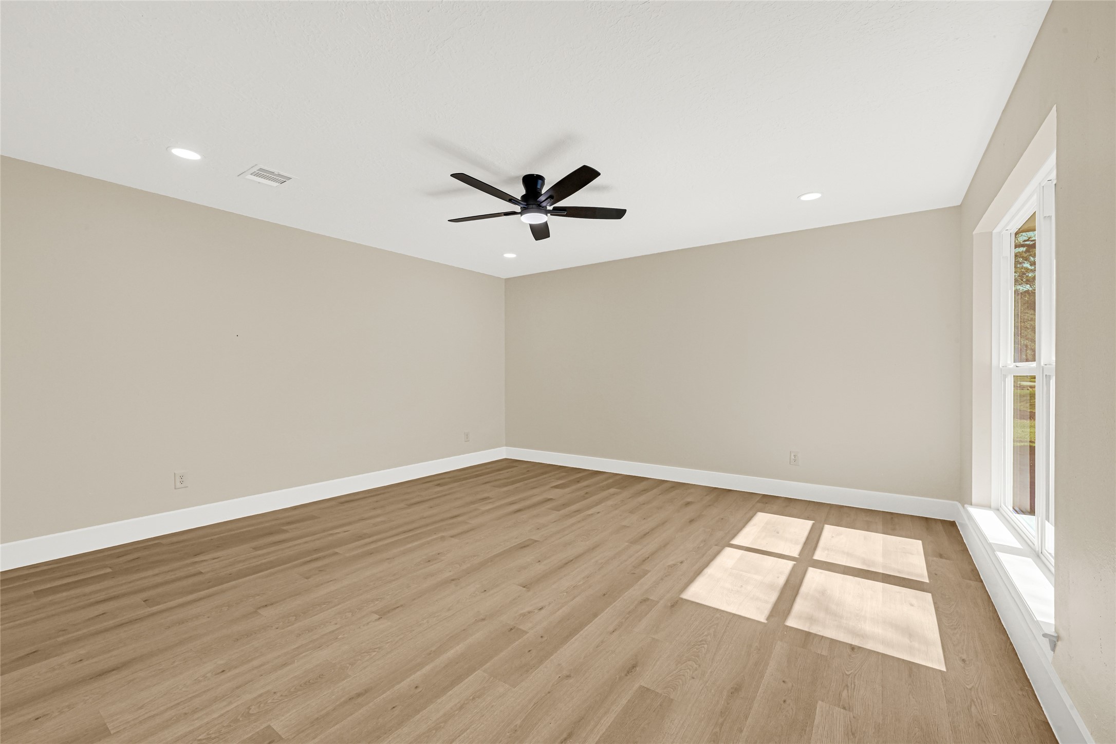 3203 Falling Brook Drive Houston, TX 77345 - Photo 16 of 27 an empty room with wooden floor and windows