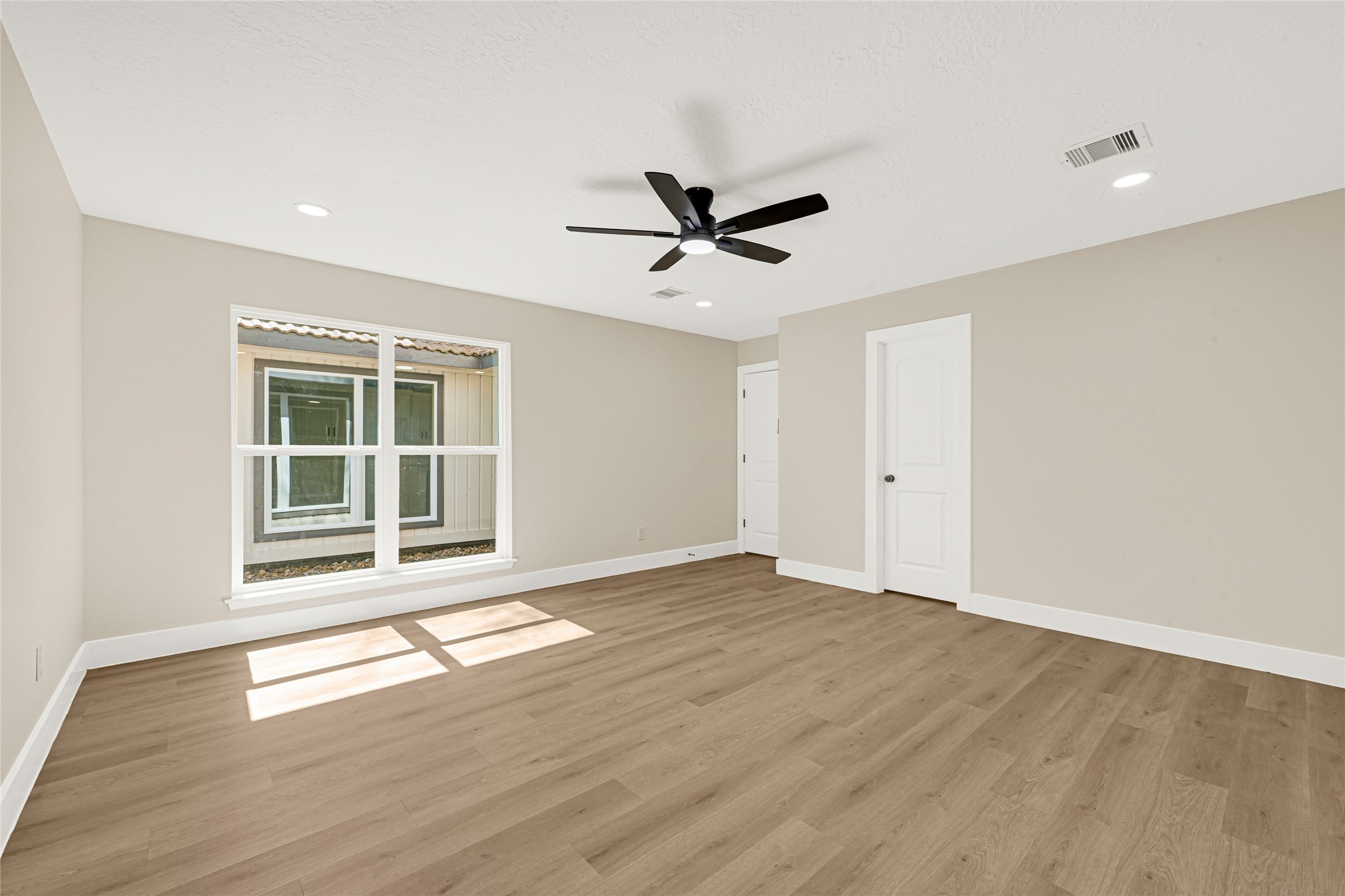 3203 Falling Brook Drive Houston, TX 77345 - Photo 17 of 27 a view of an empty room with a window and wooden floor