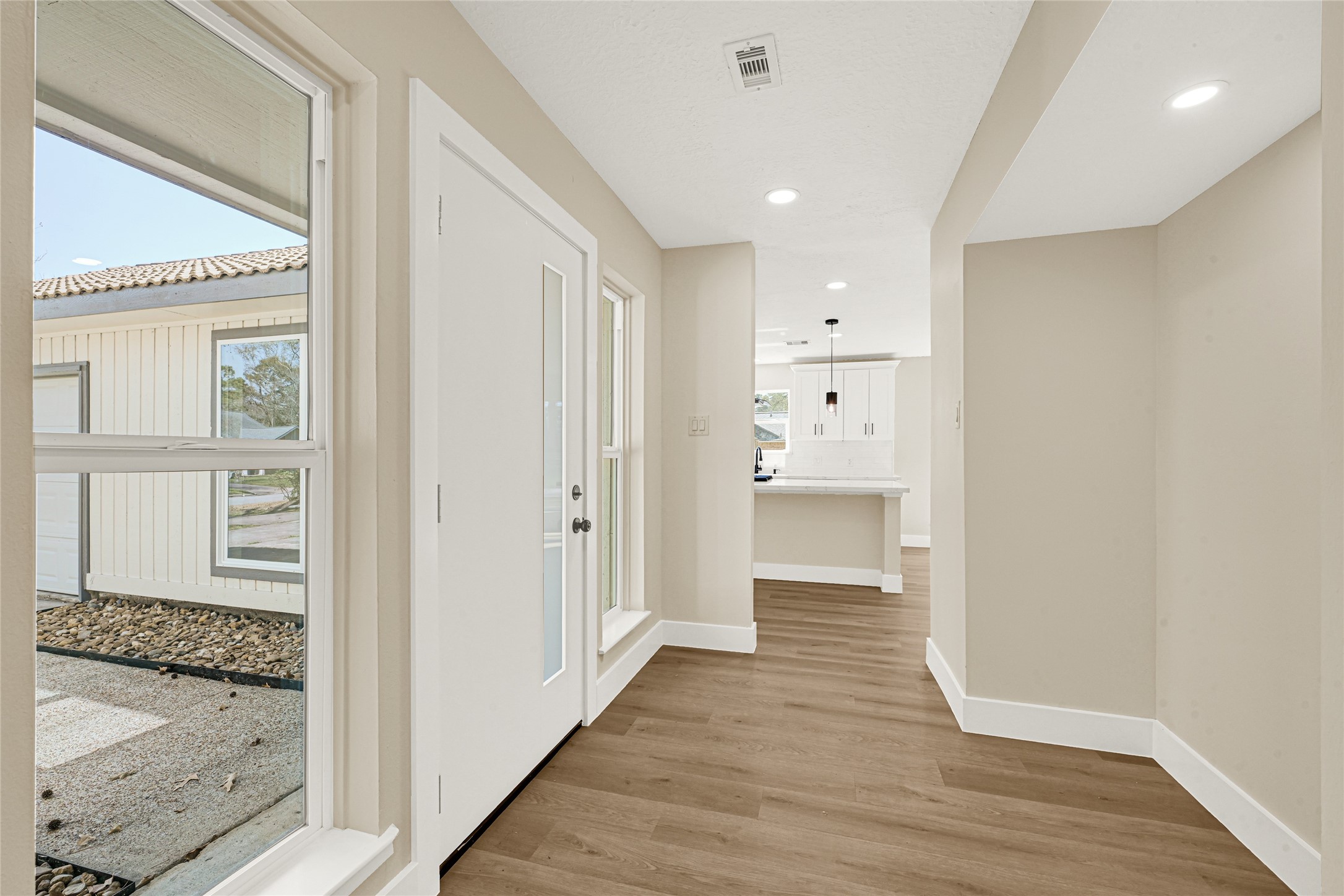 3203 Falling Brook Drive Houston, TX 77345 - Photo 4 of 27 a view of a hallway with wooden floor and a bathroom