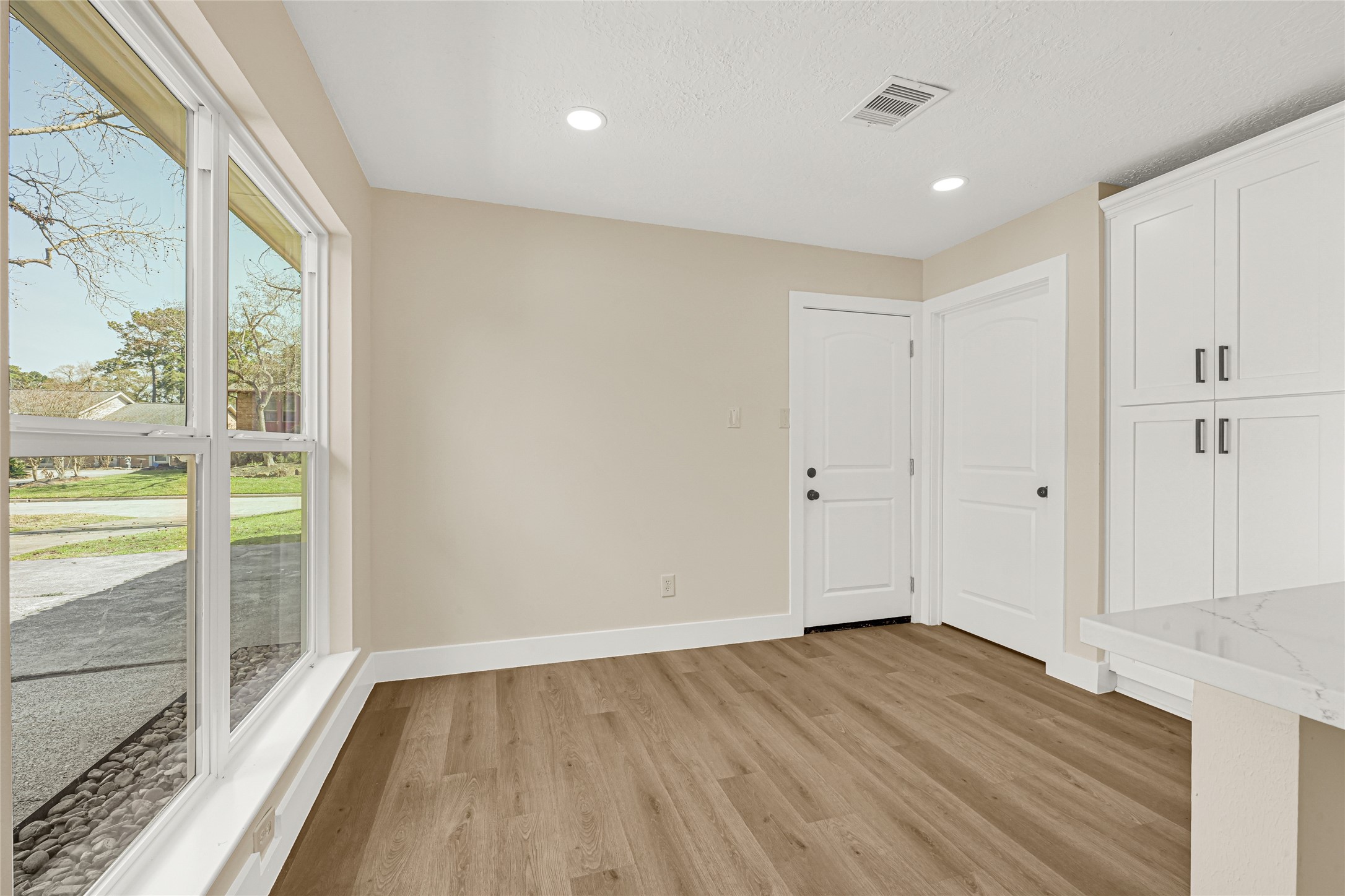 3203 Falling Brook Drive Houston, TX 77345 - Photo 8 of 27 a view of an empty room with wooden floor and a window