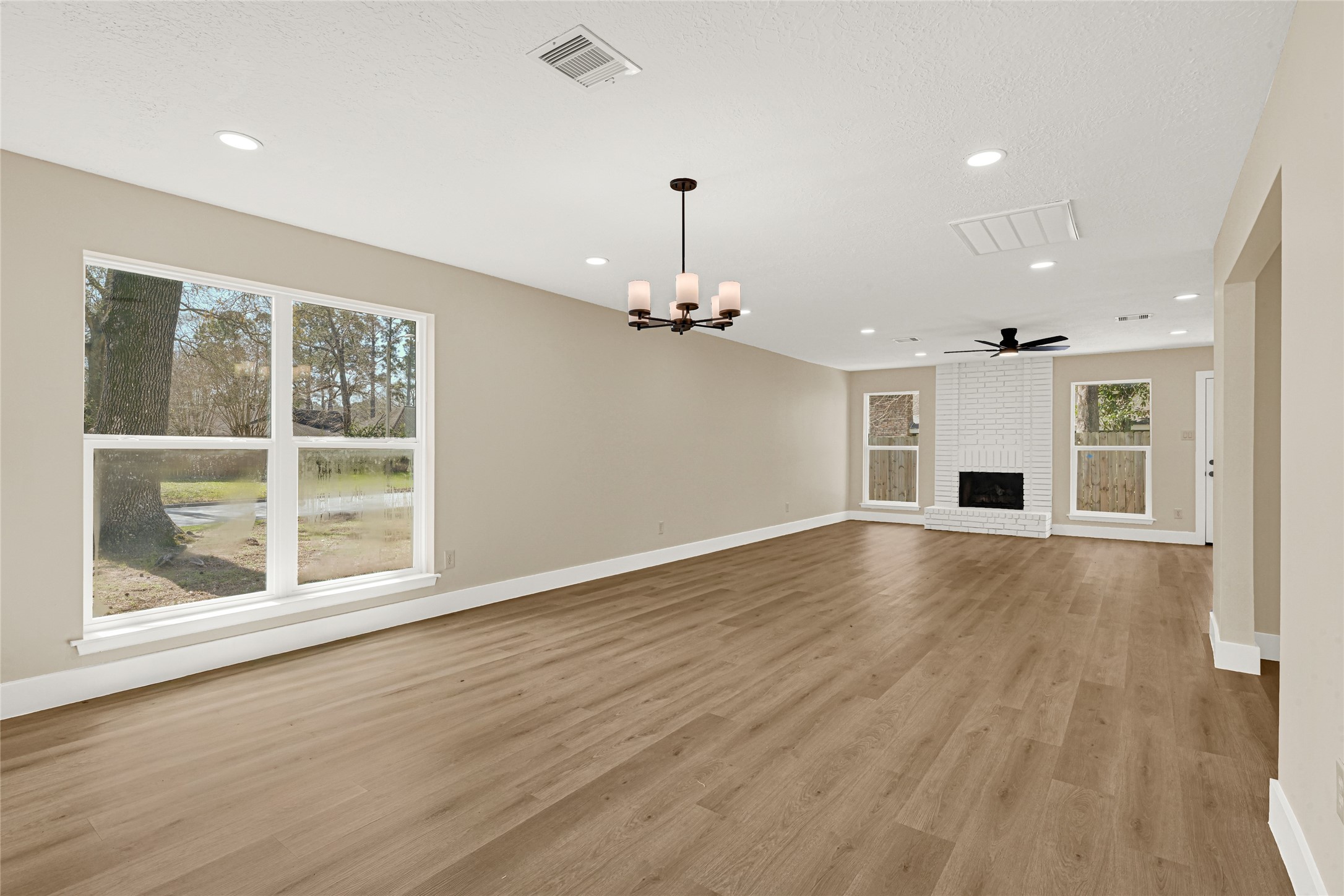 3203 Falling Brook Drive Houston, TX 77345 - Photo 10 of 27 a view of an empty room with wooden floor fireplace and a window