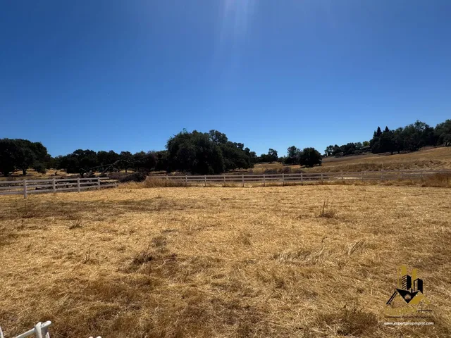 a backyard view of a house with barbeque oven table and chairs
