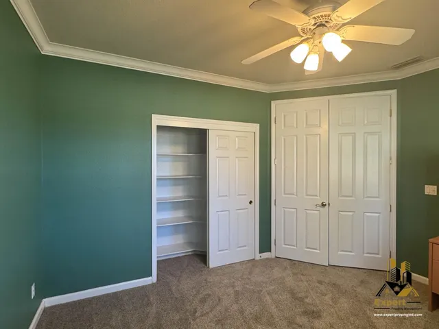 an empty room with closet and fan