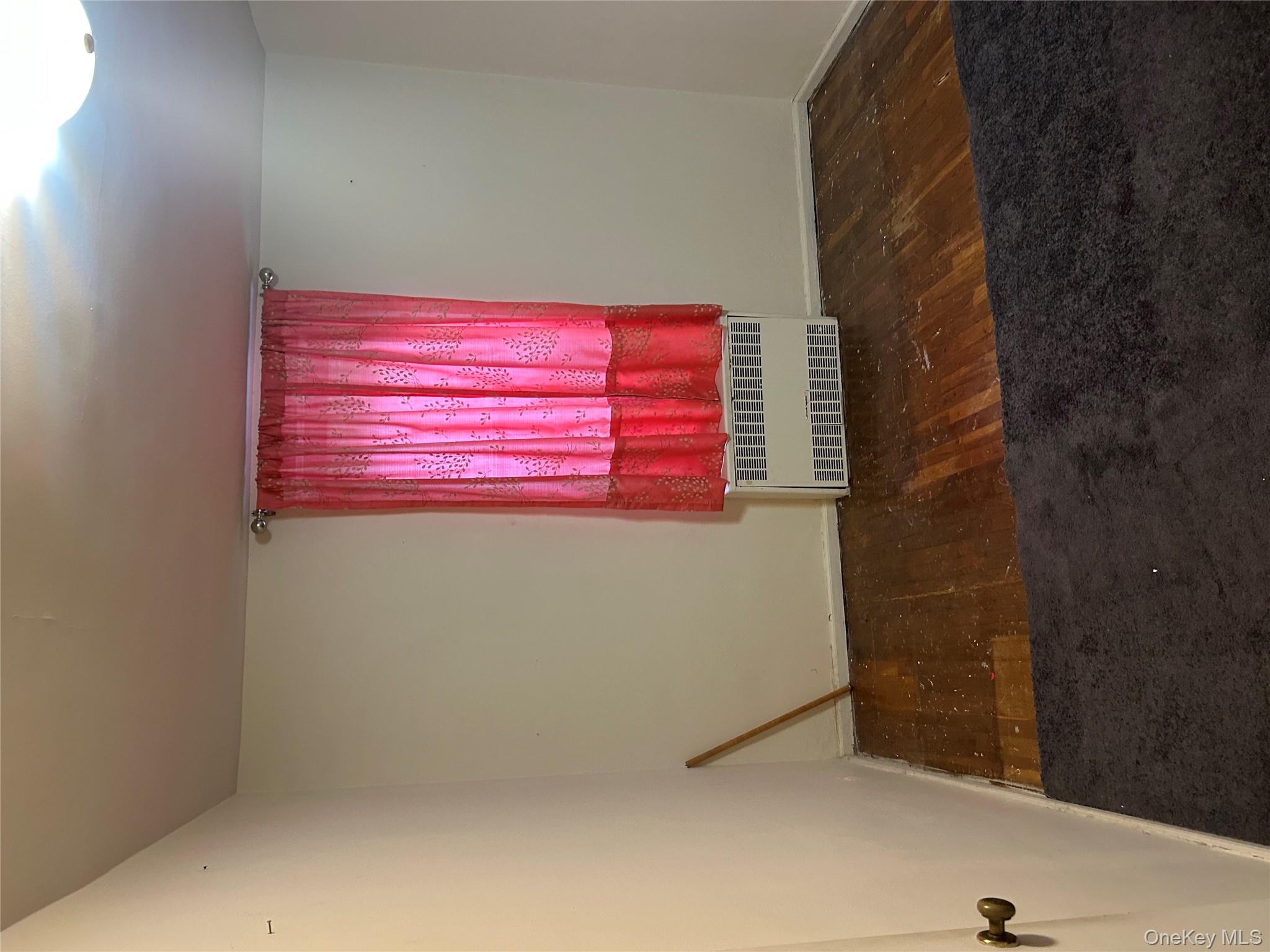 83-25 98th Street, Unit 2C Queens, NY 11421 - Photo 14 of 18 an empty room with wooden floor and windows