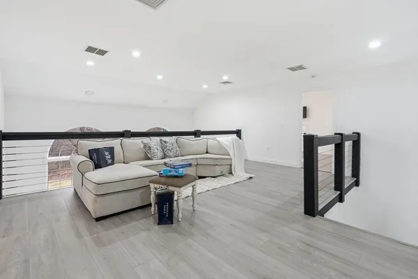 a living room with furniture and a wooden floor