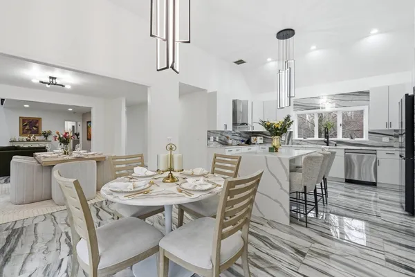 a dining room with furniture a chandelier and wooden floor