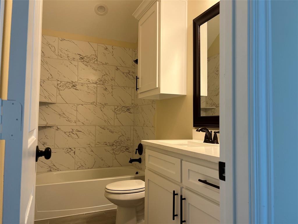 8008 County Road 1058 Rice, TX 75155 - Photo 16 of 25 Full bathroom featuring a white vanity with integrated sink, black framed mirror, and matte black fixtures